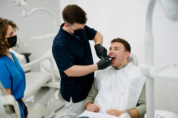 Male dentist preparing patient for dental bridge fitting